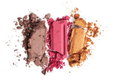 Bronzda ezilmiş göz farı, beyaz arka planda pembe ve altın renkler. Parıldayan kozmetik tozu parçalara ayrıldı. Reklam ve markalaşma için güzellik makyaj dokusu..