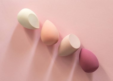 Pembe makyaj süngerleriyle en az güzellik kompozisyonu. Yumuşaklık, denge, ritim ve modern kadın estetiğini ifade eden temiz kozmetik kavramı.