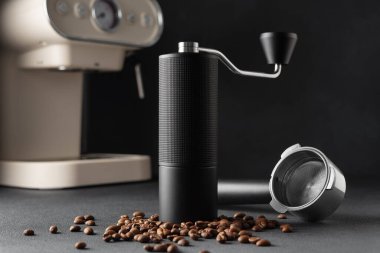 Arka planda espresso kahve makinesi olan siyah el yapımı kahve öğütücüsü. Özel kahveyi, zanaatkarlığı, dikkatli ritüeli, kaliteli birayı ve ev kahvecisi yaşam tarzını simgeleyen minimum sade yaşam..