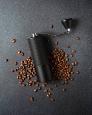 Koyu dokulu arkaplanda kavrulmuş fasulye ile elle kahve öğütücü. Özel kahve ve yaşam tarzı kavramları için ideal..