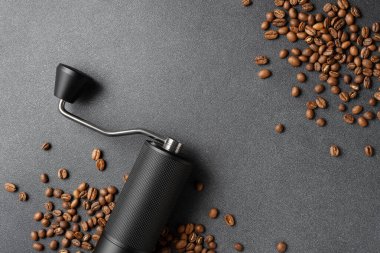 Koyu dokulu arkaplanda kavrulmuş fasulye ile elle kahve öğütücü. Özel kahve ve yaşam tarzı kavramları için ideal..