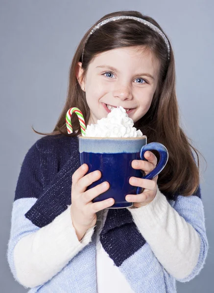 Hübsches kleines Mädchen mit heißem Kakao und Zuckerrohr — Stockfoto