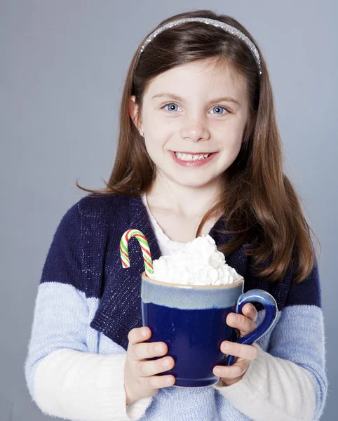 Hübsches kleines Mädchen mit heißem Kakao und Zuckerrohr — Stockfoto