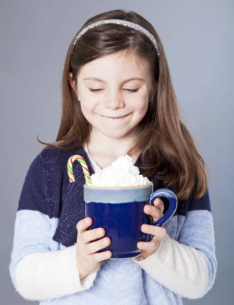 Kleines Mädchen starrt auf eine köstliche Tasse heißen Kakao mit Süßigkeiten — Stockfoto
