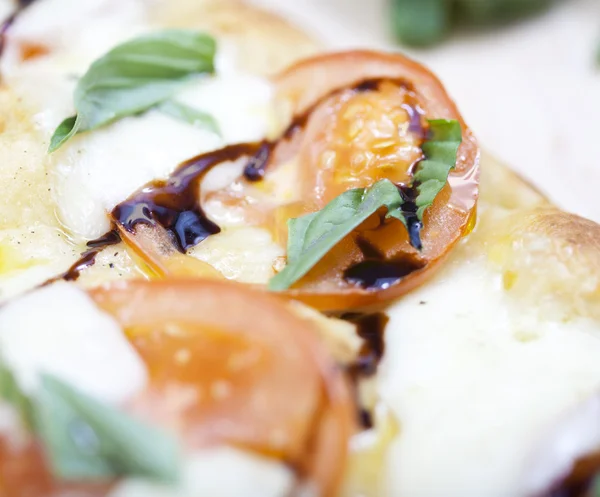 Fresh pizza with tomato, mozzarella and basil on wooden board — Stock Photo, Image