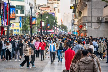 Wuhan Çin, 14 Şubat 2021: 2021 Çin yılbaşı tatilinde Wuhan Hubei Çin 'deki Jianghan yaya yolunda cerrahi maske takan bir kalabalık