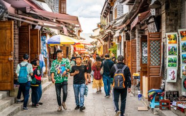 Dali China , 6 October 2020 : Chinese tourists and old Bai buildings in Xizhou ancient town street in Dali Yunnan China clipart