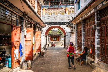 Dali Çin, 6 Ekim 2020: Zhoucheng antik köy sokağı manzarası Bai azınlık kadınlarıyla Zhoucheng Dali Yunnan Çin 'de geleneksel elbise