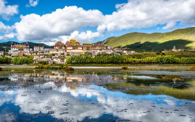 Shangri-La Yunnan Çin 'de göl ve su yansıması olan Songzanlin Manastırı.