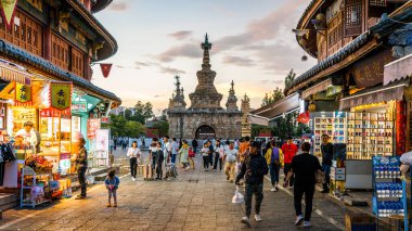 Kunming Çin, 4 Ekim 2020: Eski Jingang Pagoda halkı ve Kunming Yunnan Çin 'de günbatımında renkli dükkanlarla Guandu' nun eski güzel sokak manzarası