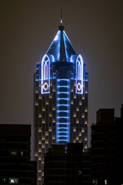 Haikou China, 21 Mart 2021: Landmark Tower binasının tepesine dikey olarak bakmak gece Haikou Hainan Çin 'de 260 metre yüksekliğindeki bir gökdeleni aydınlattı