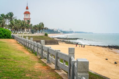 Haikou beachside panorama with the Guanhaitai clock tower in Haikou Hainan China clipart