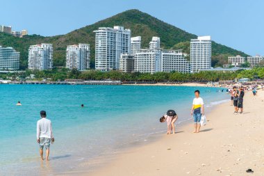Sanya Çin, 25 Mart 2021: Dadonghai 'da Çinliler güneşli bir günde Sanya Hainan Adası' nda güzel bir plaj.