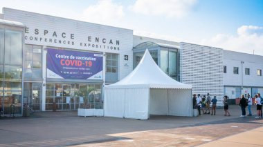 27 July 2021 , La Rochelle France : View of Covid vaccination center of Espace Encan and people queuing-up in front of it during summer 2021 in La Rochelle France clipart