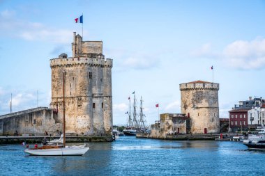 La Rochelle 'in Zinciri ve Saint Nicolas Kuleleri. Yazın mavi gökyüzü, La Rochelle Fransa' nın eski limanının girişini gösteriyor.