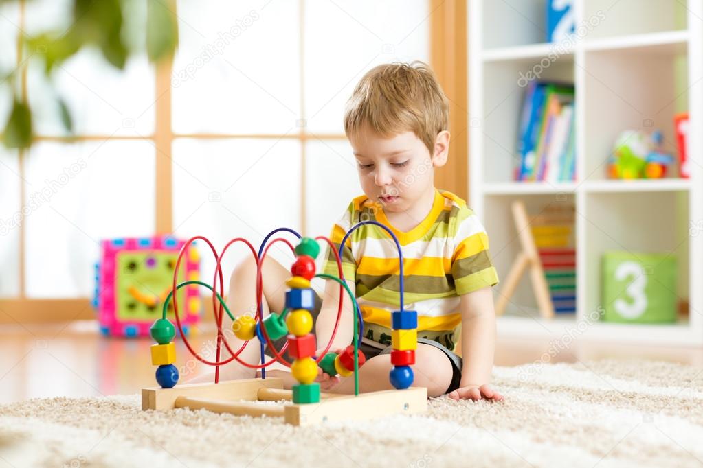 Preschooler child playing with colorful toy. Kid playing with