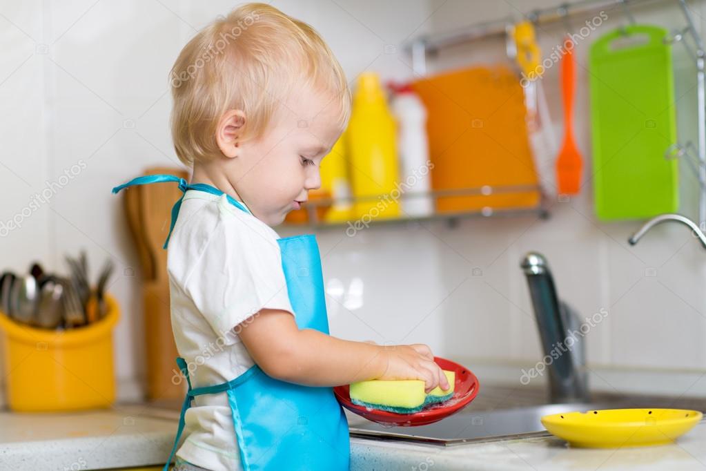 Child washing dishes in a domestic kitchen — Stock Photo © oksun70