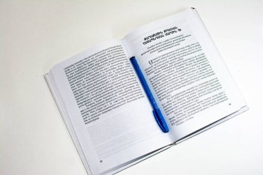 Masadaki kitap ve kalemi aç.