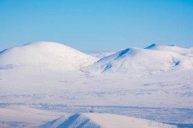 Dağlar ve tarlalar beyaz karla kaplıdır.
