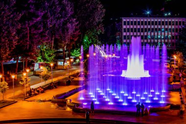 Güzel mimari evleri ve fıskiyesi olan güzel bir şehir meydanı. Şehir meydanında fıskiyeler. Renkli çiçeklerle dolu bir gece meydanı. Gece şehri Kapan.