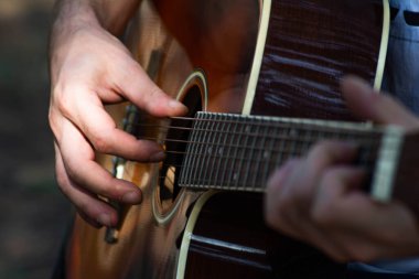 Gitar bir gitaristin elinde. Adam gitar çalıyor. İspanyol gitarı. Gitar dizgileri