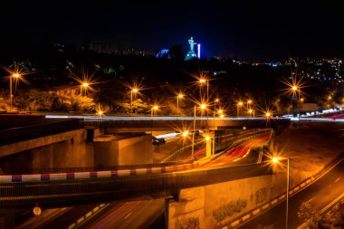 Geceleri otobanlarda araba trafiği. Köprüdeki arabaların hareketi. Güzel mimarisi ve anıtları olan bir gece şehri. Gece şehrinin aydınlık yolları. Gece şehir hayatı