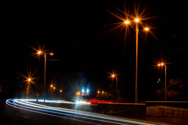 Colored traffic of cars in the night city. Car traffic at night. Street lamps shine at night