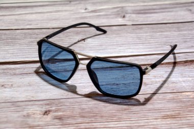 Ahşap arka planda güneş gözlüğü. Siyah güneş gözlüğü. Moda gözlükleri.