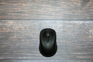 Tahta arka planda bilgisayar faresi. Kopyalama alanı olan üst görünüm. Masadaki bilgisayar için kablosuz fare