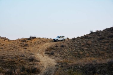 Dağlarda bir SUV. Çölde bir araba. Bir off-road aracı bir dağ yolundan iniyor.