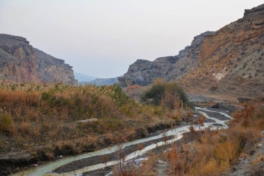 A river flows through a canyon. High rocky mountains and a river. Beautiful natural scenery.