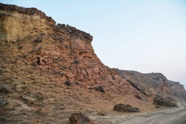 Çölde bir kanyon. Çıplak dağlar ve bir kanyon. Mars 'taki gibi güzel bir doğa. Kanyonun kayalık duvarları yüksektir. Dağ manzarası