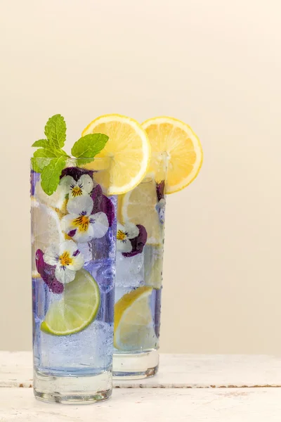 Cocktail with edible violet flowers — Stock Photo, Image