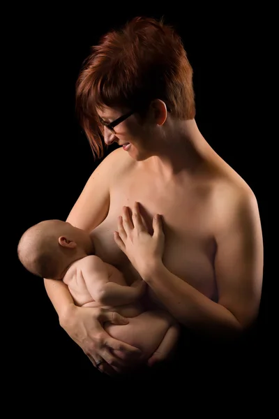 Mãe amamentando contra preto — Fotografia de Stock
