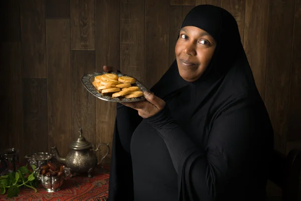 Mujer musulmana africana presentando galletas — Foto de Stock