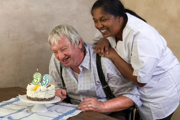 Pensionista feliz com bolo de aniversário — Fotografia de Stock