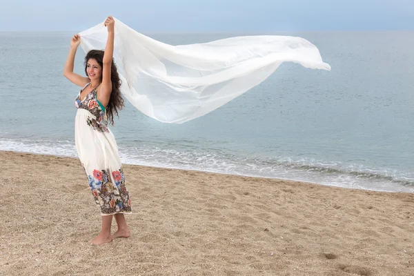 Девушка на пляже с шарфом — стоковое фото