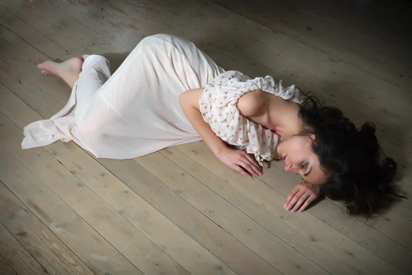 Lonely woman on wooden floor — Stock Photo, Image