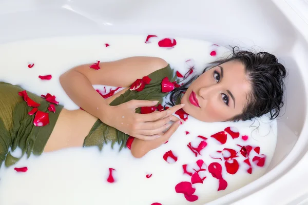 Молочная ванна с лепестками роз — стоковое фото