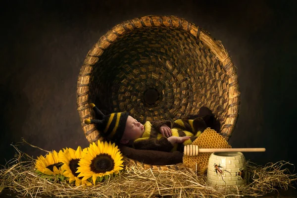 可愛いです赤ん坊寝ていますでビー衣装でアンティーク蜂の巣 — ストック写真