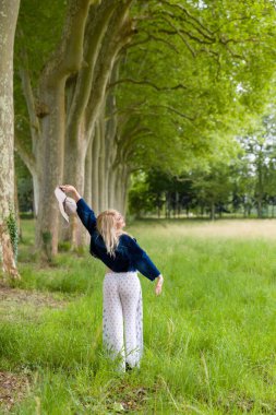 Yazın kırsalda dans eden güzel sarışın kadın.