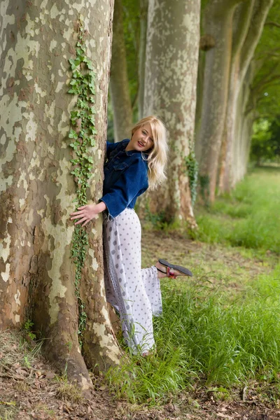 아름다운 금발의 여자가 나무를 껴안고 — 스톡 사진