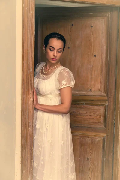 本物の摂政のドレスの若い女性が戸口に立って — ストック写真