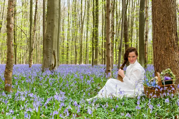 Lang haar vrouw in bluebells bos — Stockfoto
