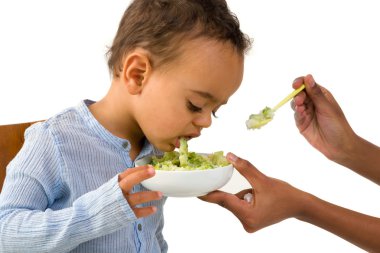 African boy refusing his vegetables clipart
