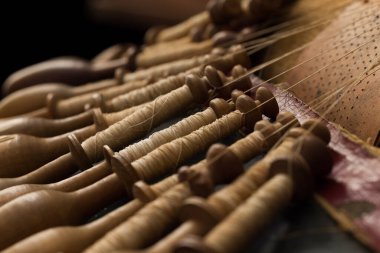 Eski bir Flaman dantelinin çok eski ahşap kaplamalı yastığının yakın plan görüntüsü.