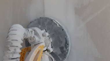 DIY tadilatı sırasında alçıdan yapılmış dairesel zımpara makinesi ev ya da apartman dairesinde çalışıyor. Kendin yap..