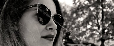 Şehirde güzel bir kız. Güzel bir kadınla siyah beyaz fotoğraf. Parkta gülümseyen güzel bir genç kadın.