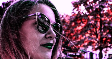 Parkta bir kadınla güzel renkli bir fotoğraf. Yeşil dudaklı kadın