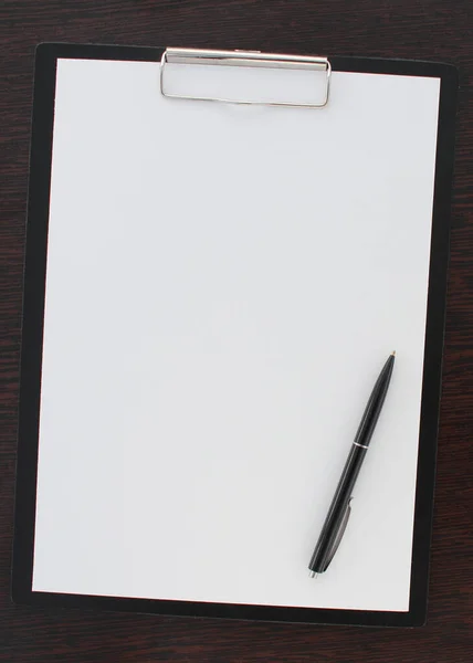 Svart penna och tomt papper som ligger på träbord — Stockfoto